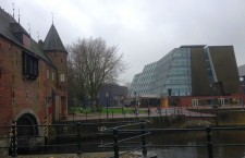Nou și vechi în Amersfoort. În stânga imaginii,   poarta medievală Koppelpoort,   în dreapta,   clădirea Agenției pentru Patrimoniu Cultural